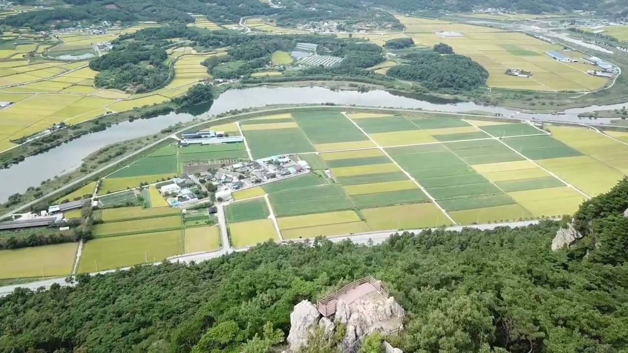 산위에서 드론을 날리며 다가가는 평온한 농촌 들녘